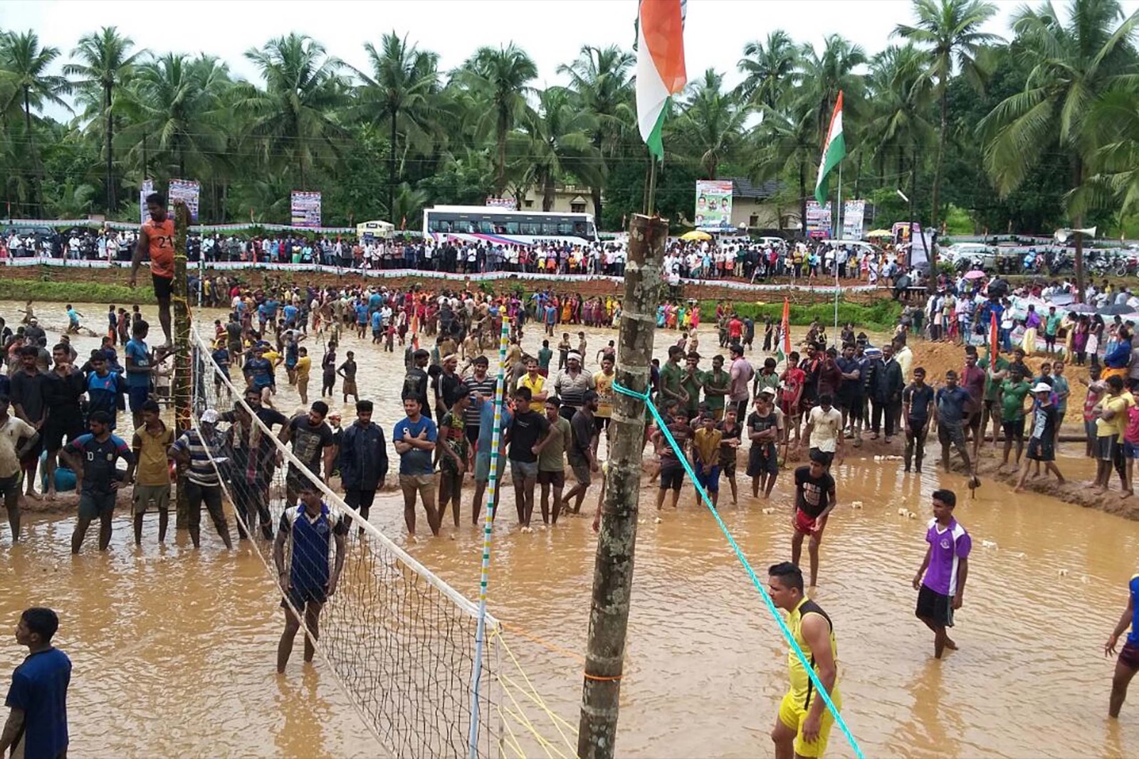 Crowds around a mud volleyball court at the Kesared Onji Dina rural games in Bajagoli